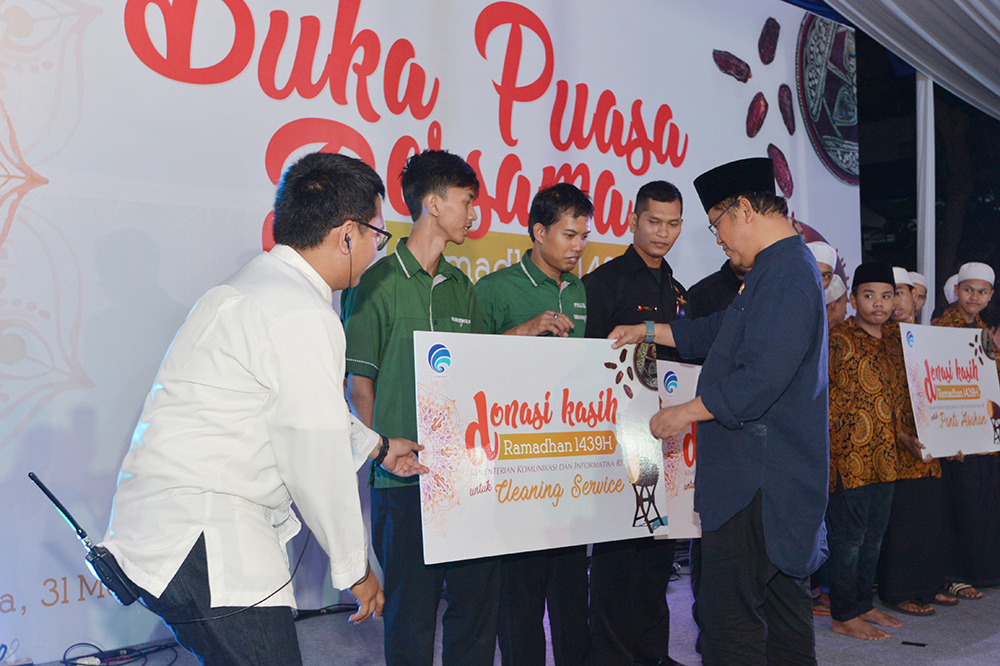 Menkominfo Rudiantara menyerahkan donasi kepada anak-anak dari panti asuhan dan petugas keamanan serta cleaning service yang salama ini bertugas di Gedung Menara Merdeka, Kemkominfo, dalam acara buka bersama yang digelar Kemkominfo di Lapangan Ananta Kupa, Kemkominfo, di Jakarta, Kamis (31/5/2018).