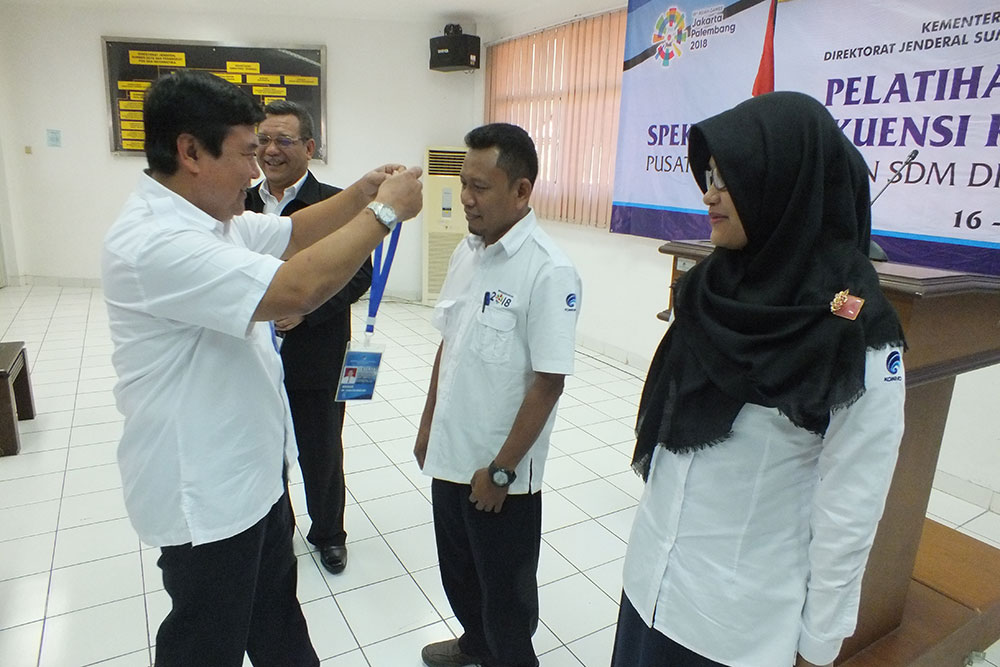 Sekretaris Ditjen SDPPI Sadjan disaksikan Kepala Pusdiklat Kemkominfo Usuluddin mengalungkan kartu peserta dalam Pelatihan Monitoring Spektrum Frekuensi Radio Batch II di PPSDM Ditjen SDPPI, Cidokom, Cisarua, Bogor, Jawa Barat, Senin (16/7/2018).