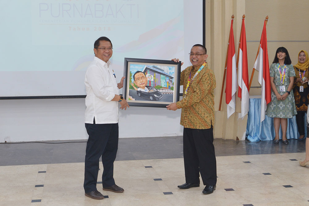 Menkominfo Rudiantara menyerahkan kenang-kenangan gambar karikatur kepada Lala M. Kolopaking, Staf Ahli Menteri Bidang Sosial, Ekonomi, dan Budaya di Kemkominfo, yang memasuki masa purnabakti pada Agustus 2018, dalam acara pelepasan 18 pegawai purnabakti di Ruang Serbaguna Abdulghani, Gedung Kemkominfo, Jakarta, Jumat (31/8/2018).