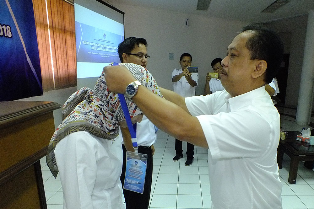 Sesditjen SDPPI R. Susanto mengalungkan tanda peserta kepada peserta Pelatihan Monitoring Spektrum Frekuensi Radio di Wisma PPSDM Ditjen SDPPI di Cidokom, CIsarua, Bogor, Jawa Barat, Senin (15/10/2018).