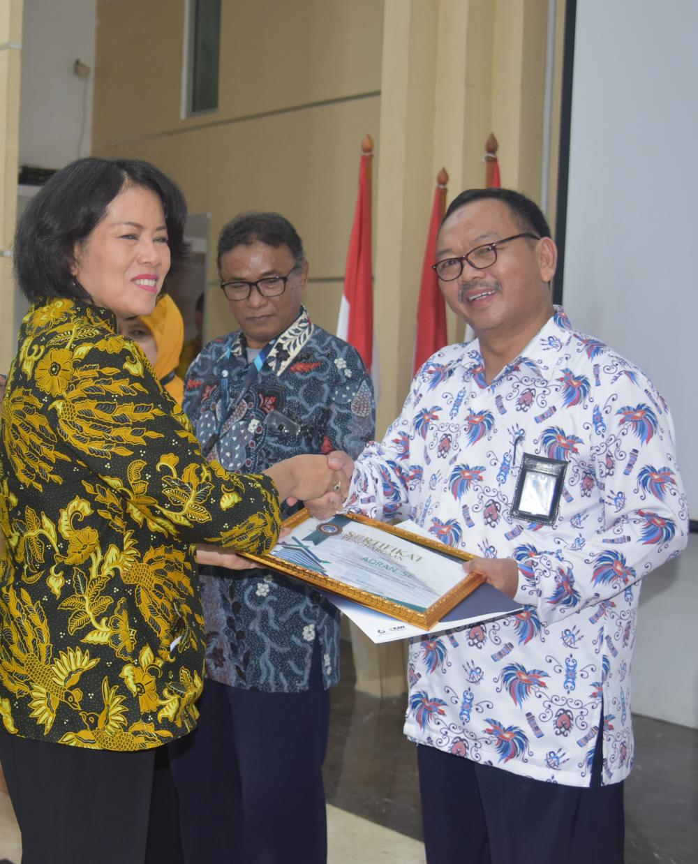 Sekjen Kemkominfo menyerahkan piagam penghargaan purabakti kepada Adran, pegawai Balmon Palembang