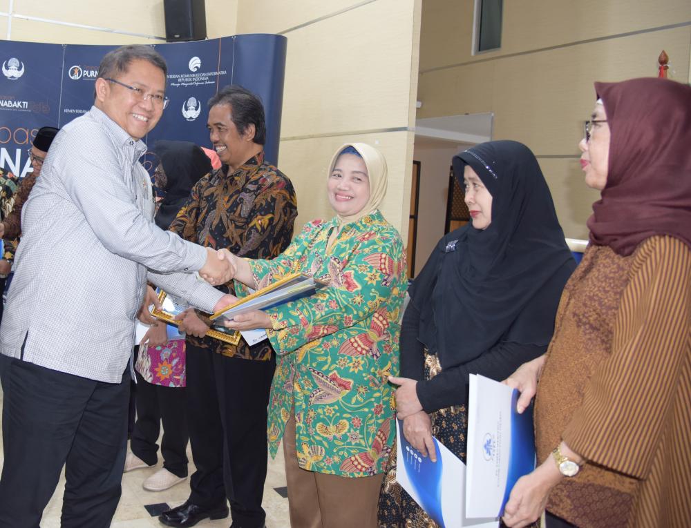 Menteri Kominfo, Rudiantara, menyerahkan piagam penghargaan kepada Rachmawati, staf Direktorat Standardisasi Perangkat Pos dan Informatika yang memasuki masa purnabhakti per 1 Juli 2019. 