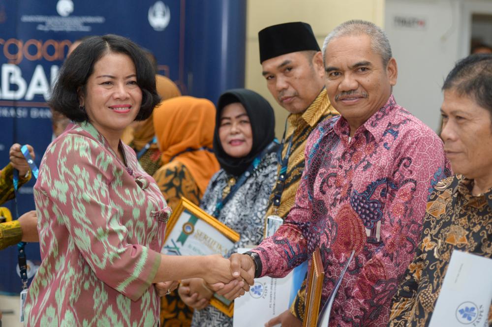 Sekretaris Jenderal Kementerian Komunikasi dan Informatika Rosarita Niken Widiastuti (kiri) berjabat tabgan dengan Joni Adrian, Kepala Balai Monitor Kelas I Semarang (kanan) pada acara pelepasan pegawai yang telah memasuki purnabakti, Jakarta (29/8). Joni merupakan salah satu dari 17 pegawai Kominfo yang telah memasuki purnabakti.