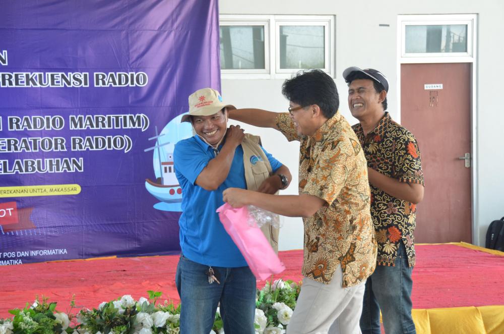 Kasubdit Sertifikasi Operator Radio Dodik Sudiyono menyerahkan rompi kepada salah seorang nelayan peserta kegiatan sosialisasi MOTS di Makassar (1/11/2019).