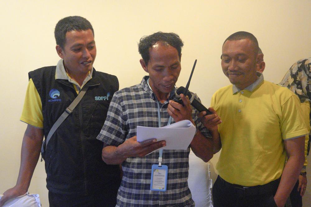 Seorang peserta melakukan simulasi komunikasi melalui radio dalam Bimtek bagi Nelayan di Kab. Mamuju, Senin (20/03/2023).