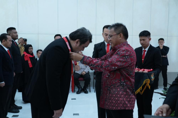Ilustrasi: Plt. Sesditjen SDPPI Sabirin Mochtar mengalungkan tanda kepada salah satu peserta diklat PPNS saat penutupan kegiatan, Selasa (04/06/2023).